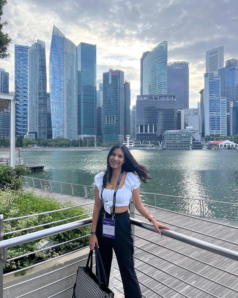 Shilika Jain at the Marina Bay railing with the Singapore financial district skyline behind her