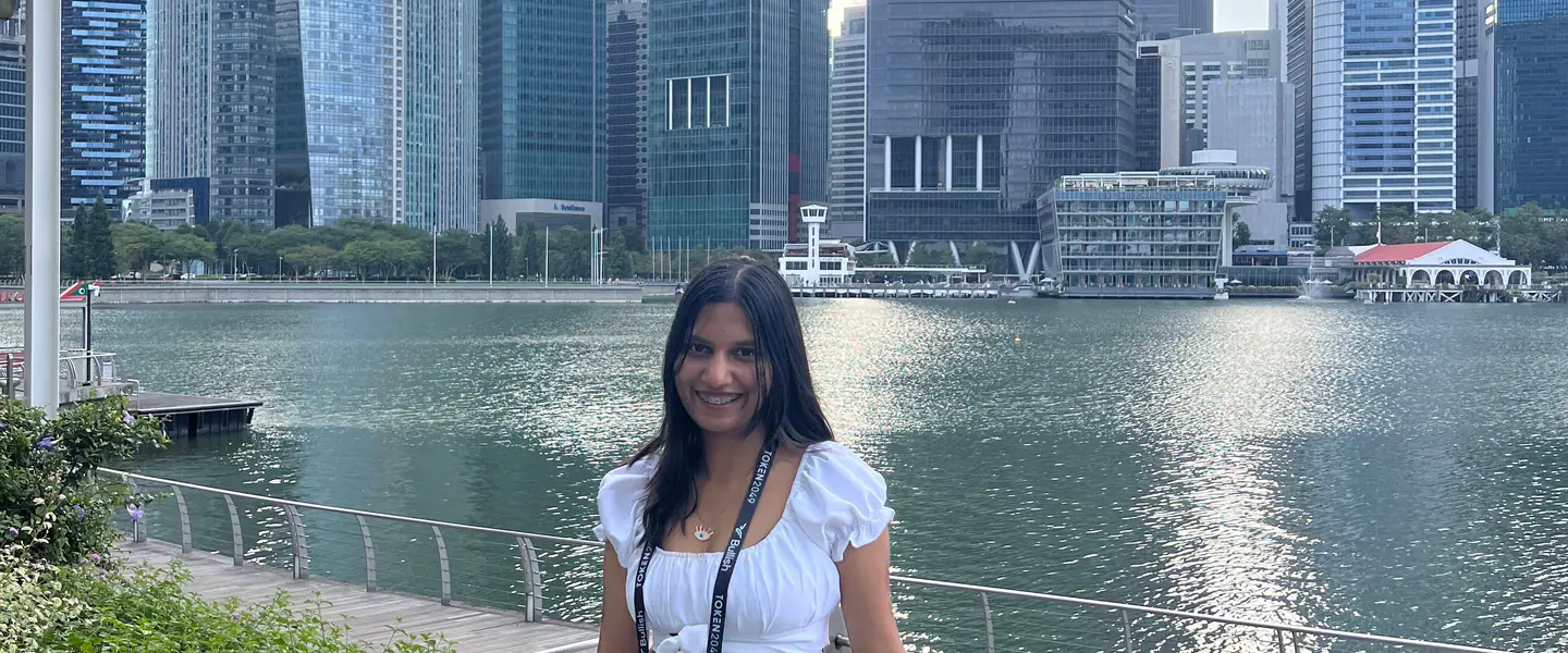 Shilika Jain leaning on the Marina Bay railing with the Singapore skyline across the water